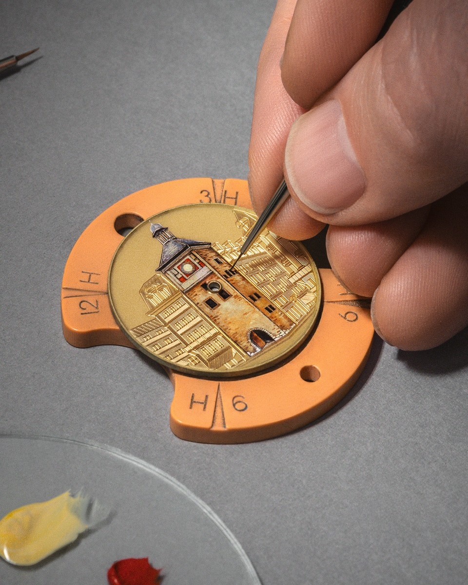Hand painting a miniature building on a watch dial with fine detail