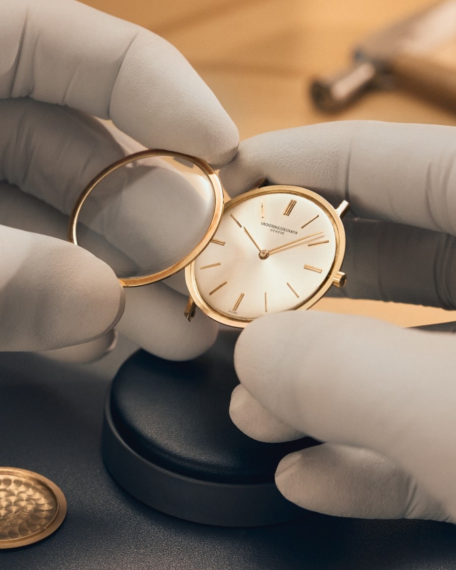 Zoomed in on the hands holding the core of the light watch with gold details