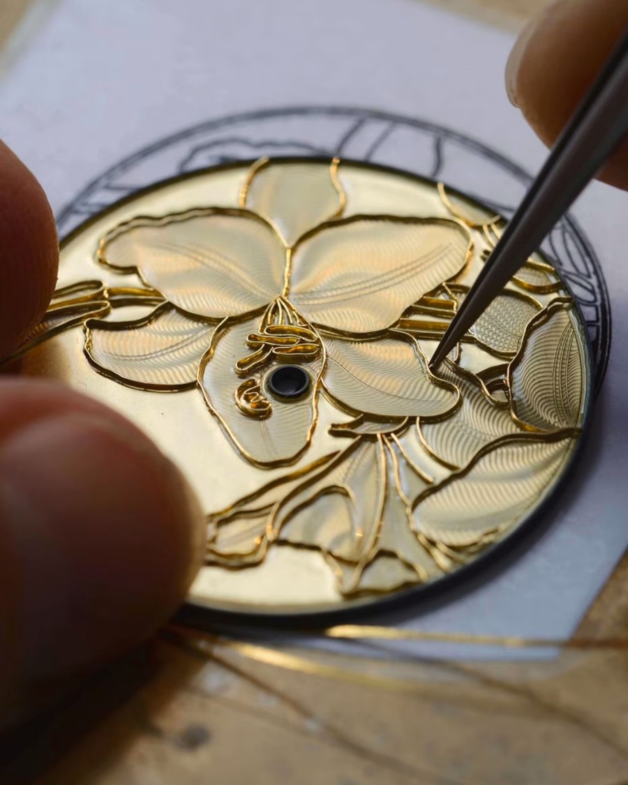 Hand engraving a floral motif on a watch dial.
